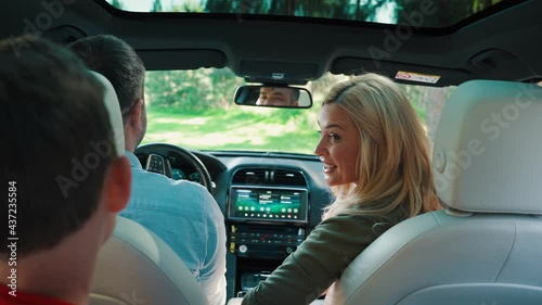 Rear view of happy family with little boy smiling while driving in the car