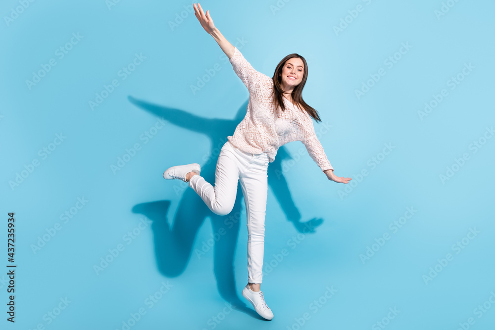 Full body photo of attractive nice young happy woman jump hands fly wings isolate on blue color background