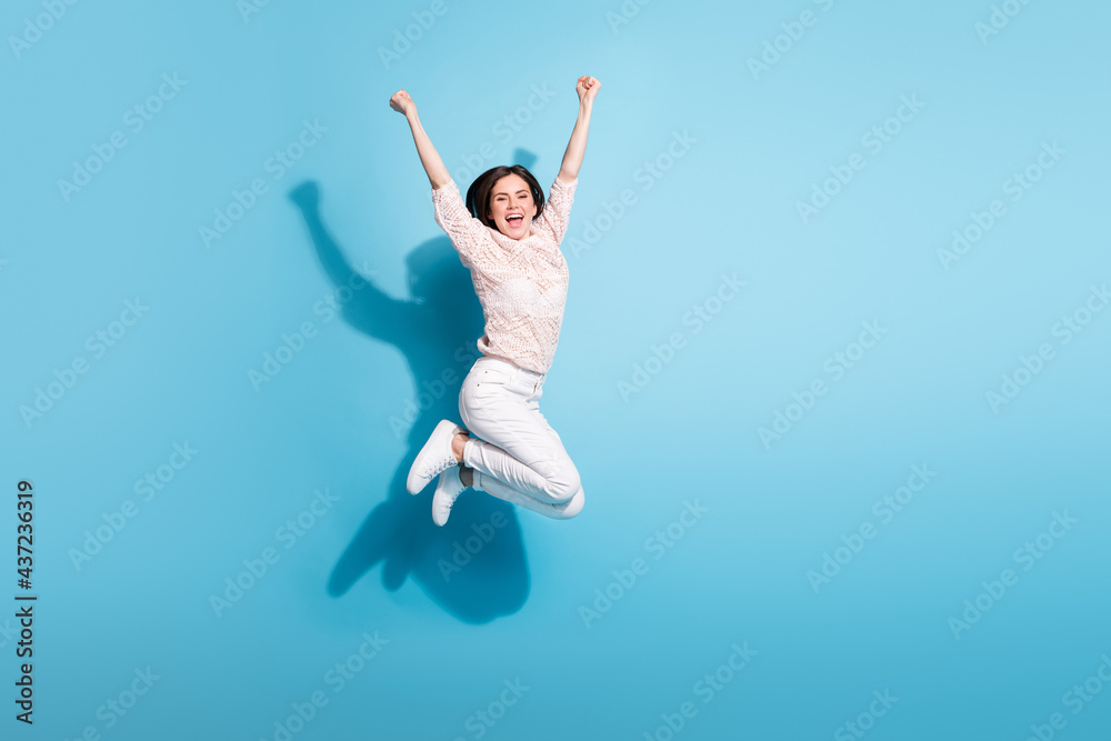 Full length photo of excited crazy happy lady jump up raise hands winner isolated on blue color background