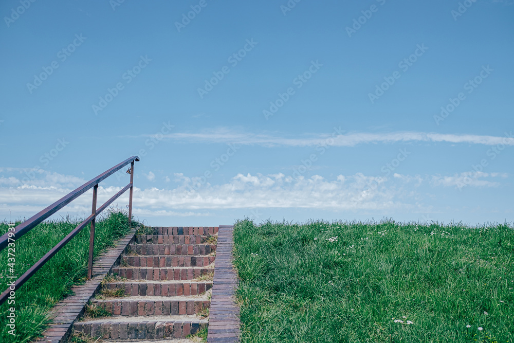 brick stairs on dike in front of blue sky