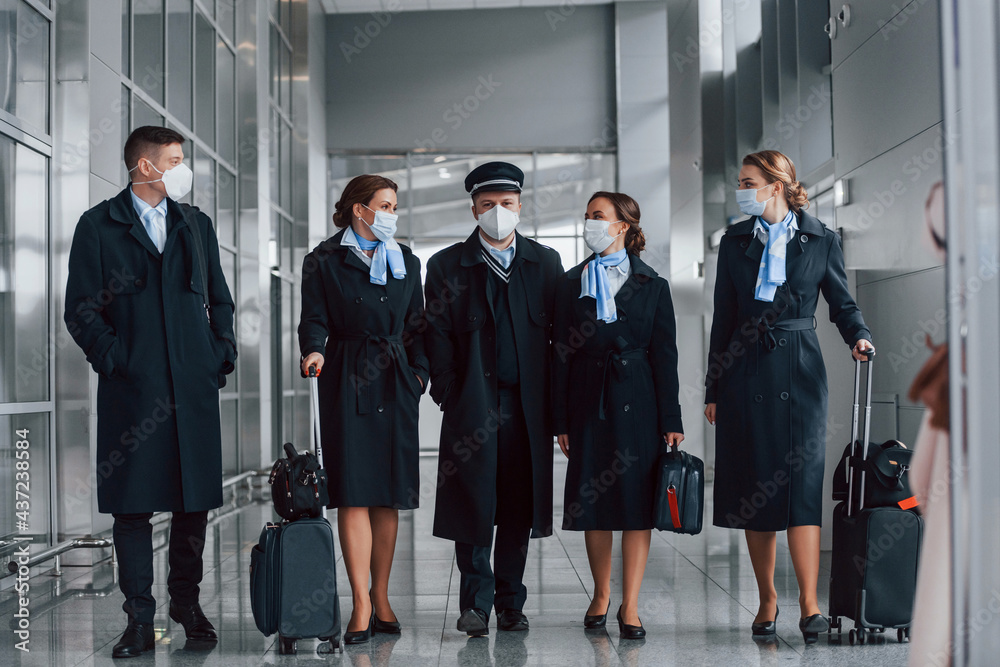 Aircraft crew in work uniform is together outdoors in the airport Aircraft crew in work uniform is together outdoors in the airport