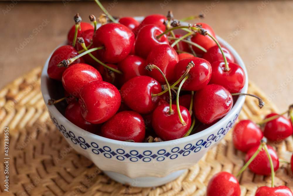 Cherries in a bowl, on a rustic wooden background. Cherries in a bowl, on a rustic wooden background.