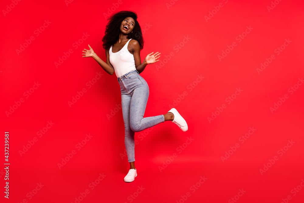 Full body photo of young excited african girl happy positive smile have fun dance party isolated over red color background Full body photo of young excited african girl happy positive smile have fun dance party isolated over red color background