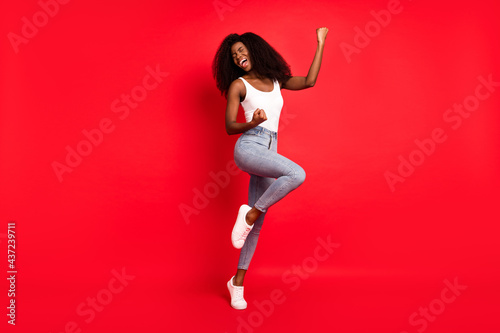 Full length photo of young attractive black girl happy positive smile rejoice win victory isolated over red color background