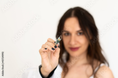 Close up image of young women female decorator posing isolated holding paintbrushes in front of her face while painting in apartment. Selective focus on brush