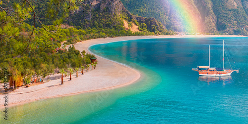 Brown gulet anchored with rainbow at the Aegean sea - Panoramic view of Oludeniz Beach And Blue Lagoon, Oludeniz beach is best beaches in Turkey - Fethiye, Turkey