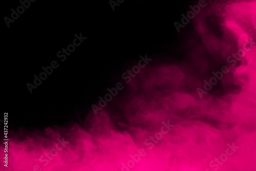 Abstract close-up of colorful pink mist or steam smoke. isolated on black background in mysterious darkness copy space