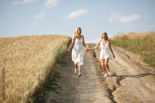 Mother with beautiful daughter in a autumn field