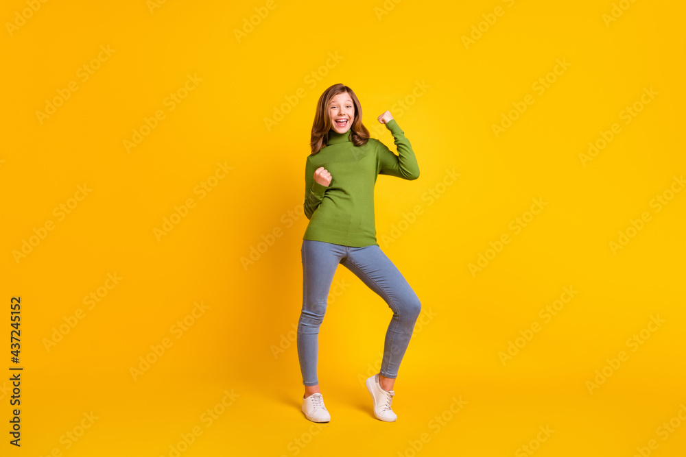Full length body size photo smiling girl in casual clothes gesturing like winner isolated vivid yellow color background