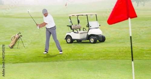 Composition of caucasian man playing golf striking with golf club next to golf cart