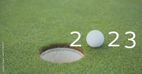 Composition of 2023 number with golf ball by hole on golf course