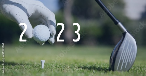 Composition of 2023 number with golf ball placed by golf player on tee on golf course