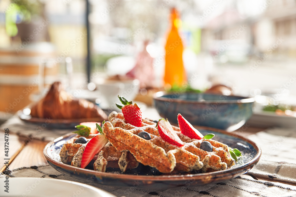 Fototapeta premium Traditional Belgian dessert - waffle with strawberry and cream.