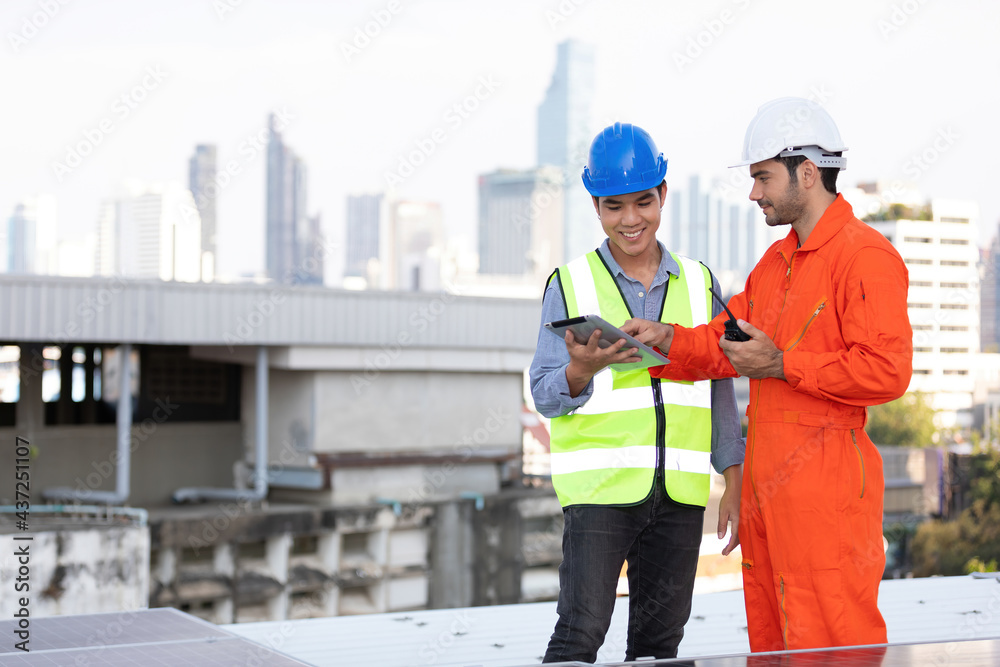 engineers or technicians holding tablet, talking about project with solar panels on the top of the roof engineers or technicians holding tablet, talking about project with solar panels on the top of the roof