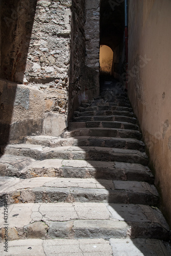 Stairs of stones in light and shadow. Vertical photo.