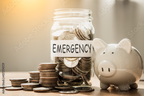 A lot coins in glass money with piggy bank for saving emergency money.Saving for emergency concept.