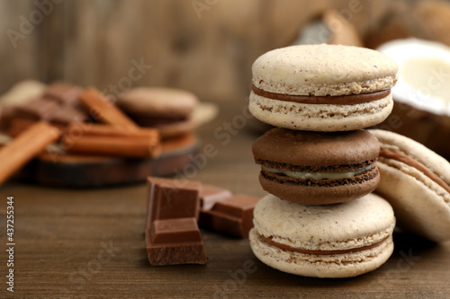 Delicious macarons and chocolate on wooden table. Space for text