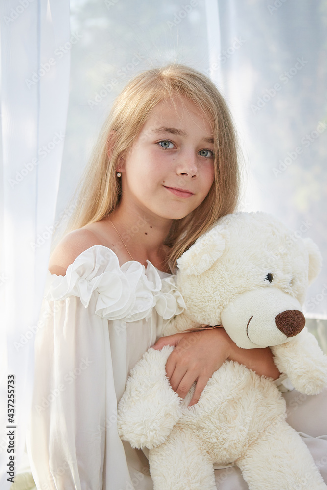 Little girl in white chiffon tent with toy