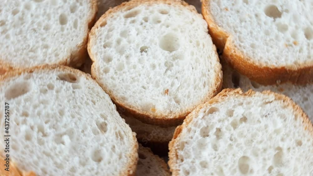 Slices of fresh French baguette rotate, close-up. Slices of fresh French baguette rotate, close-up.