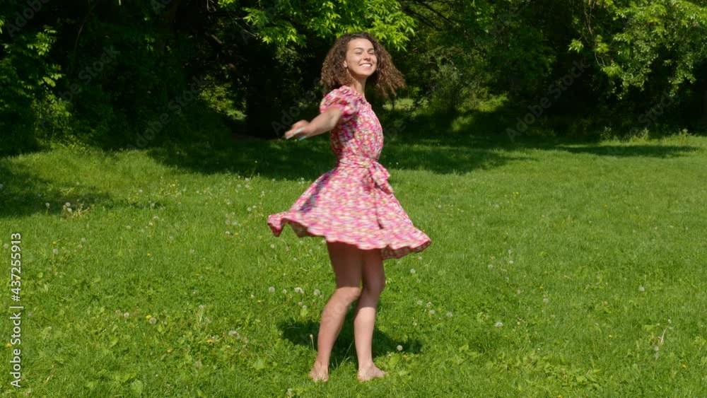 The girl in the dress dances on the lawn The girl in the dress dances on the lawn