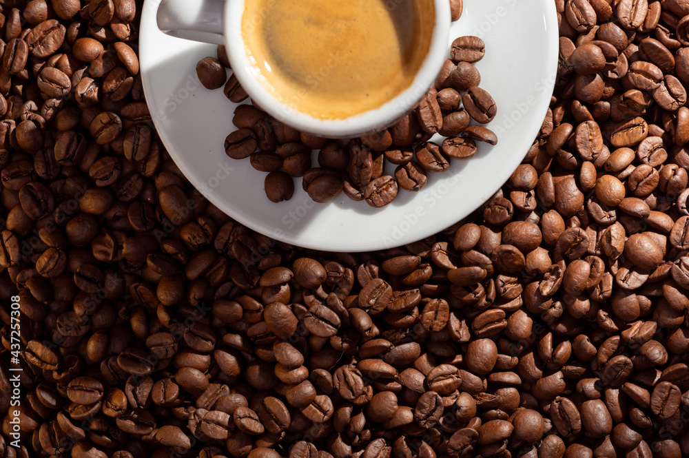 Checker with espresso coffee on a saucer and coffee grains Checker with espresso coffee on a saucer and coffee grains