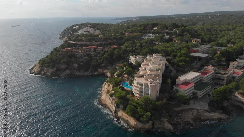 Drone point of view rocky coastline of Mallorca touristic city. Coastal hotels, architecture surrounded on Mediterranean Sea. Baleares, Spain