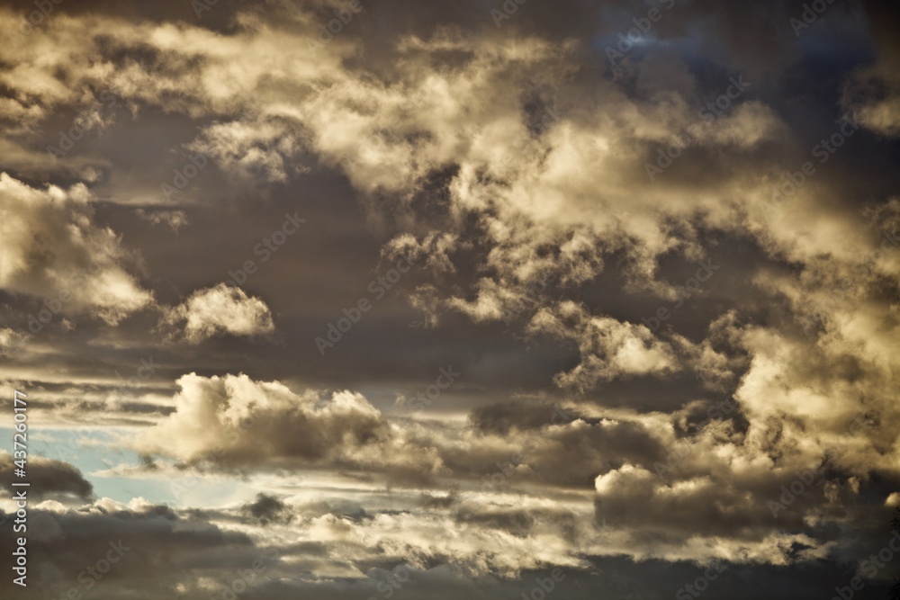 Obraz premium Bright colorful thunder clouds in the sunset light. Picturesque clouds in the evening light. Colorful abstract high contrast sunset sky. Dramatic sky. Abstract backgrounds and textures.