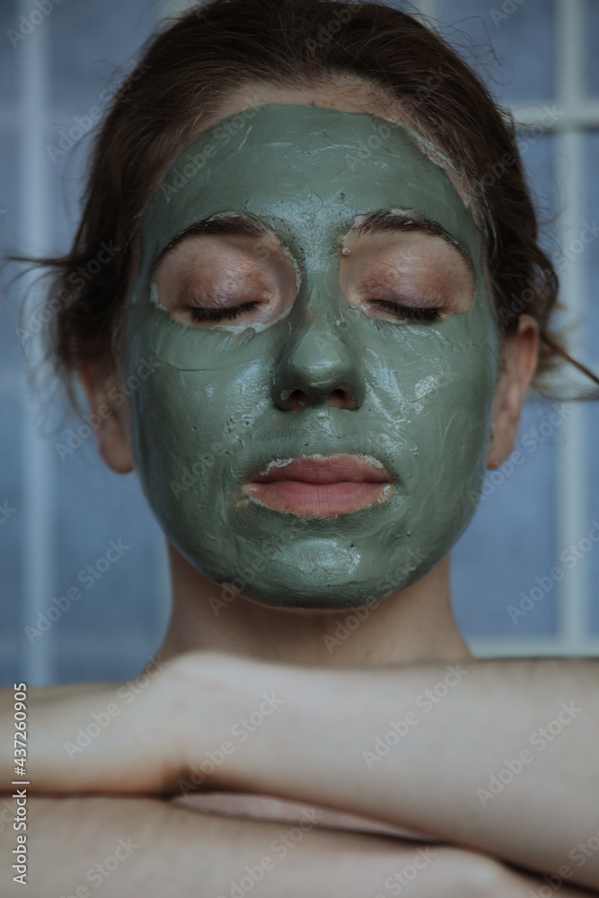 woman with the green clay face mask meditating woman with the green clay face mask meditating