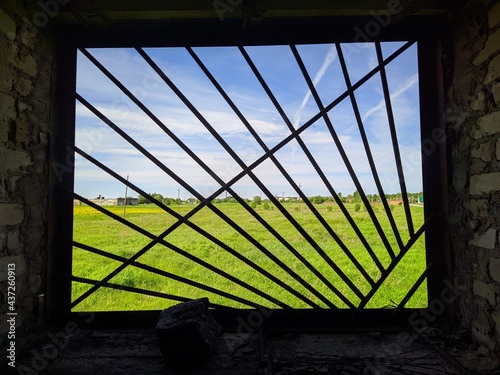 view of nature and surroundings through the lattice and broken glass of the window