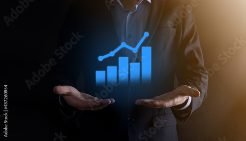 Businessman man holding a graph with positive profits growth. plan graph growth and increase of chart positive indicators in his business.more profitable and growing.