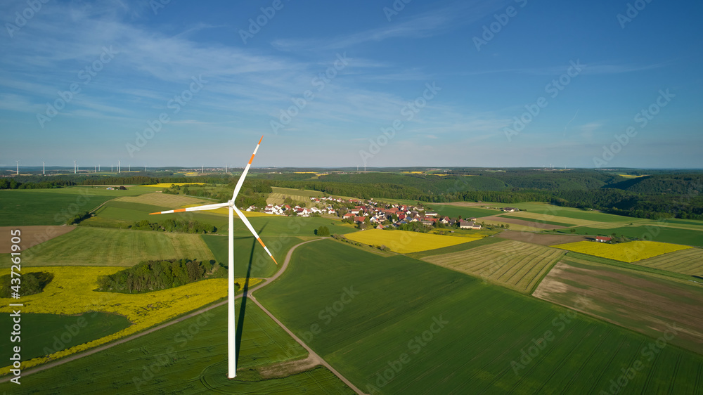 Obraz premium agriculture field with turbine near a village in germany. Swabian alb.