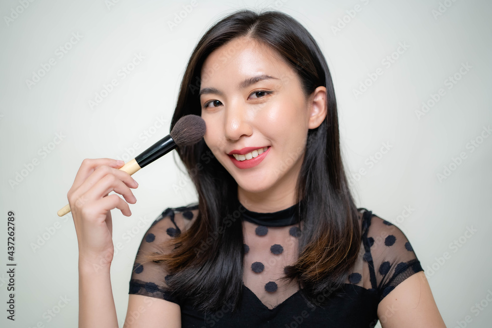 Asian women are applying foundation at the makeup table in the dressing room. Asian women are applying foundation at the makeup table in the dressing room.