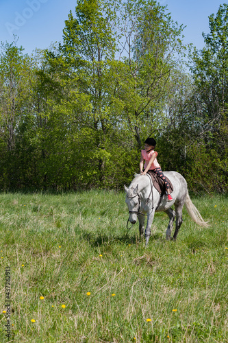 Little girl rides a white horse breed Orlov trotter © evannovostro
