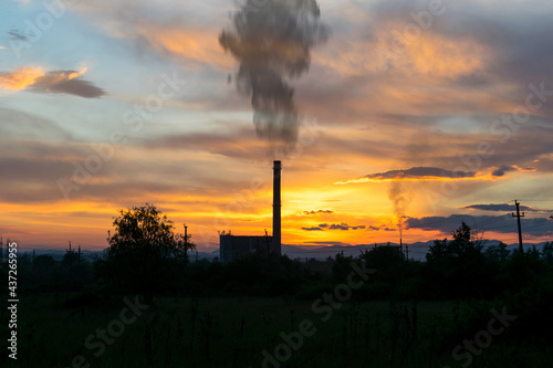 The silhouette of a thermal power plant. Spectacular sunset in the background.