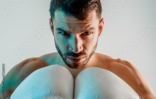 Concentrated young european male boxer in studio