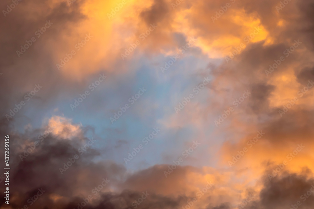Cloudy landscape. Golden clouds illuminated by sunlight at sunset.