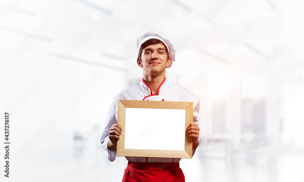 Young male chef standing near cooking table Young male chef standing near cooking table
