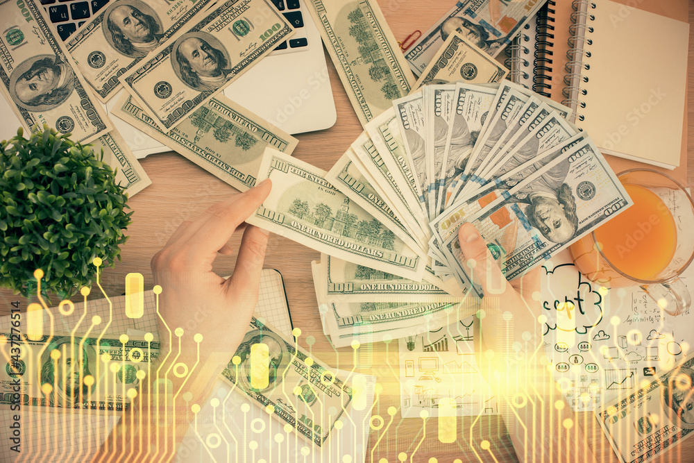 Multi exposure of technology drawing hologram and us dollars bills and man hands. Data concept Multi exposure of technology drawing hologram and us dollars bills and man hands. Data concept