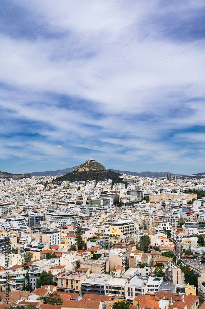 Cityscape of Athens from above. Urban architecture. Mount Lycabettus. Cloudy sky. Summer day. Tourism in Europe.