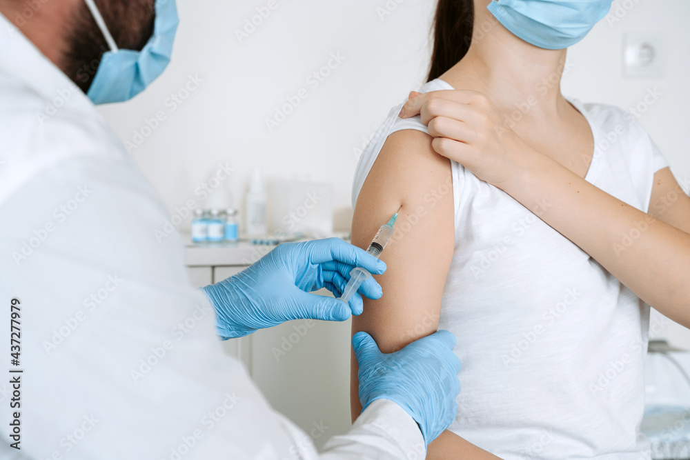 Medical staff in blue glove doing covid-19 vaccine injection to arm muscle of woman for coronavirus immunization. Medical staff in blue glove doing covid-19 vaccine injection to arm muscle of woman for coronavirus immunization.