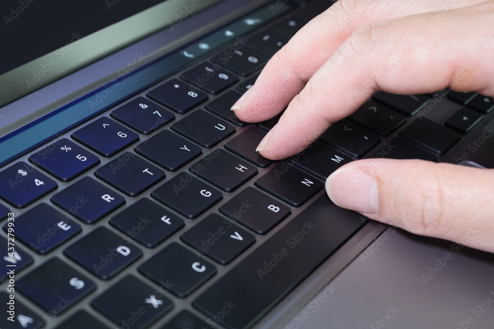 Closeup of hand typing on a laptop notebook PC computer english language keyboard which finger is on touch type keyboard button location. Closeup of hand typing on a laptop notebook PC computer english language keyboard which finger is on touch type keyboard button location.