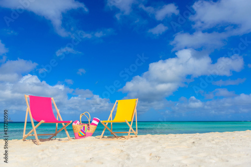 Fototapeta Naklejka Na Ścianę i Meble -  Beach chairs, beach bag, flip flops, beach towel on the shoreline, beautiful beach
