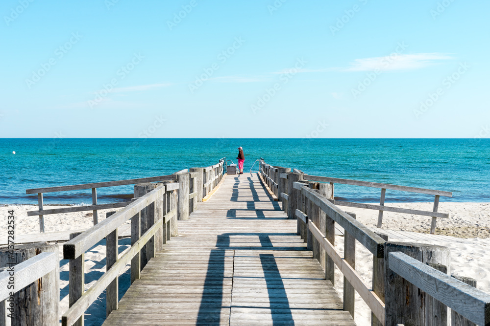 Bathing jetty on the Baltic Sea on a sunny summer day early in the morning. The sea and the sky are wonderfully blue.
