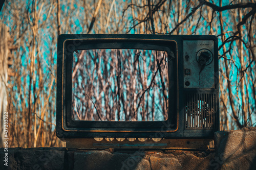 old abandoned TV with trees in the background