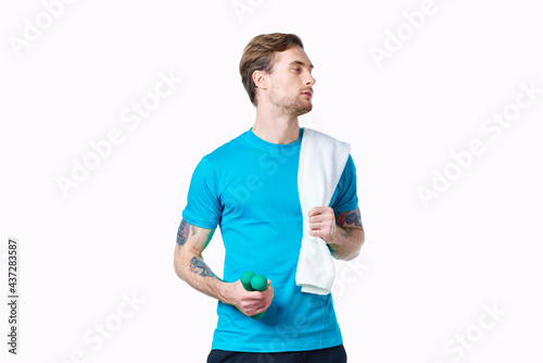 man with dumbbells in hands towel on shoulder workout fitness light background