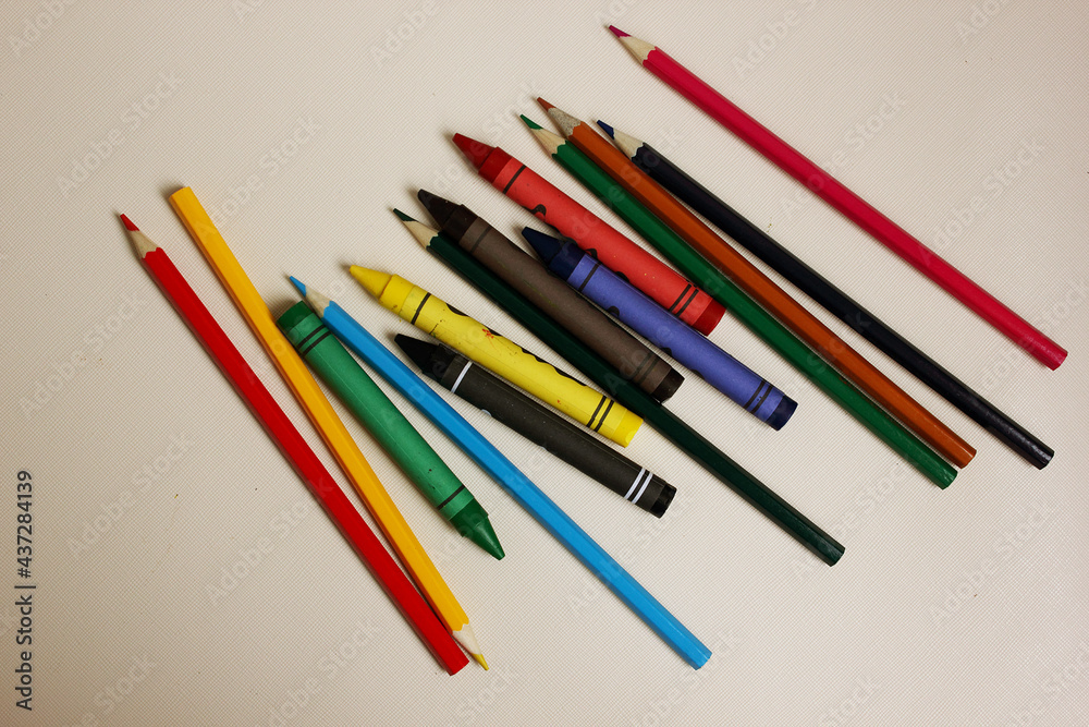 Colored pencils on a white background. Lots of different colored wax pencils. Colored pencil. Drawing lessons, hobbies, education, creativity. Close-up. Copy space. Background. Flat lay.