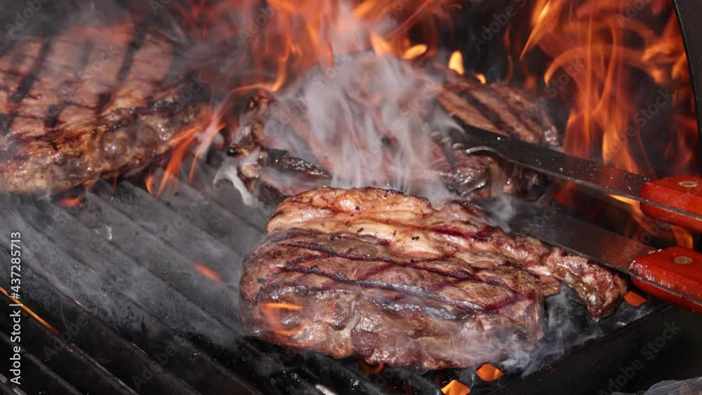 Searing and flipping ribeye steaks on grill Searing and flipping ribeye steaks on grill