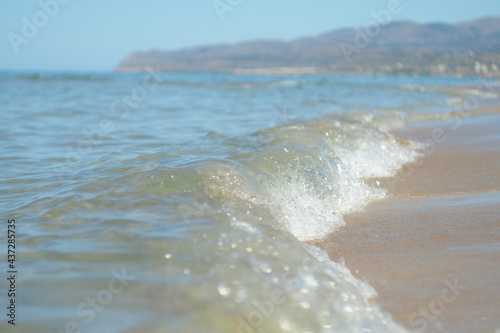 Nadchodząca fala przy piaszczystym brzegu, Kreta, Grecja