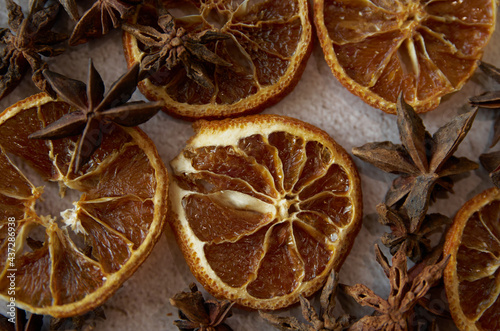 Dried orange star anise cinnamon close-up. Aniseeds, pimpinella anisum, cinnamon sticks and dried slices of an orange fruit. Spicy orange background. 