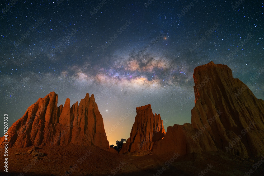 Obraz premium Beautiful milky way raised over natural earth pillar in various shapes crafted by soil erosion in Lalu, Sakaeo, Thailand